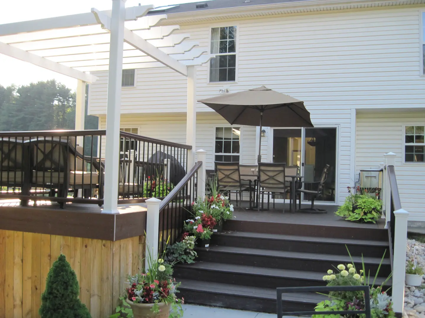 A patio with a table and chairs on the back deck.