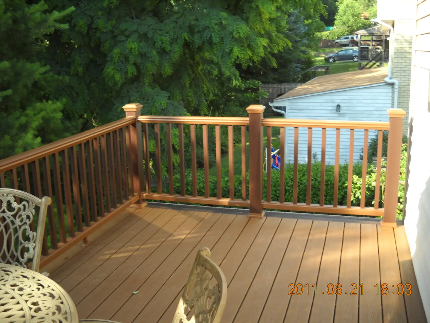 A deck with a view of the water and trees.