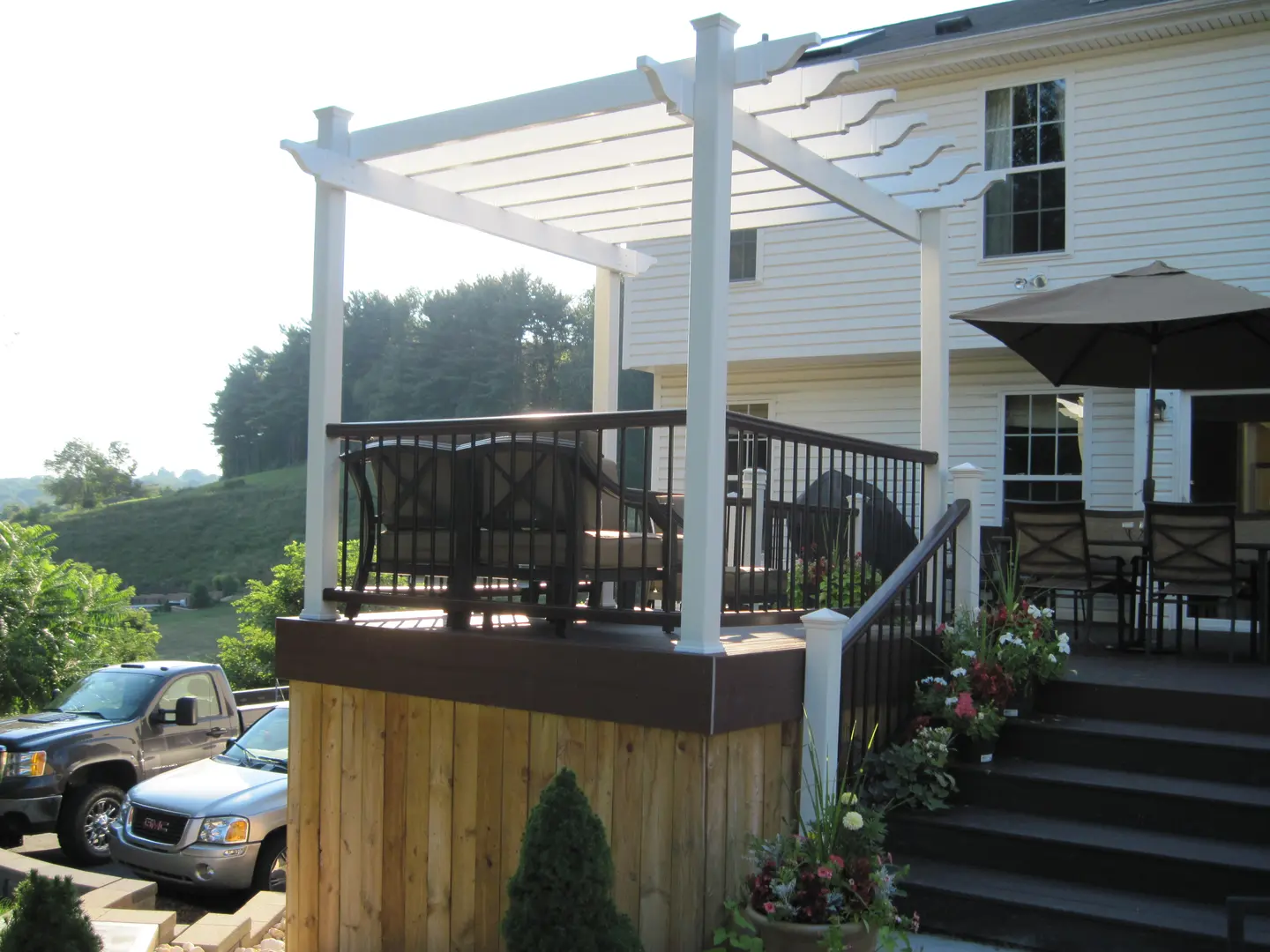 A deck with a pergola and stairs to the back.