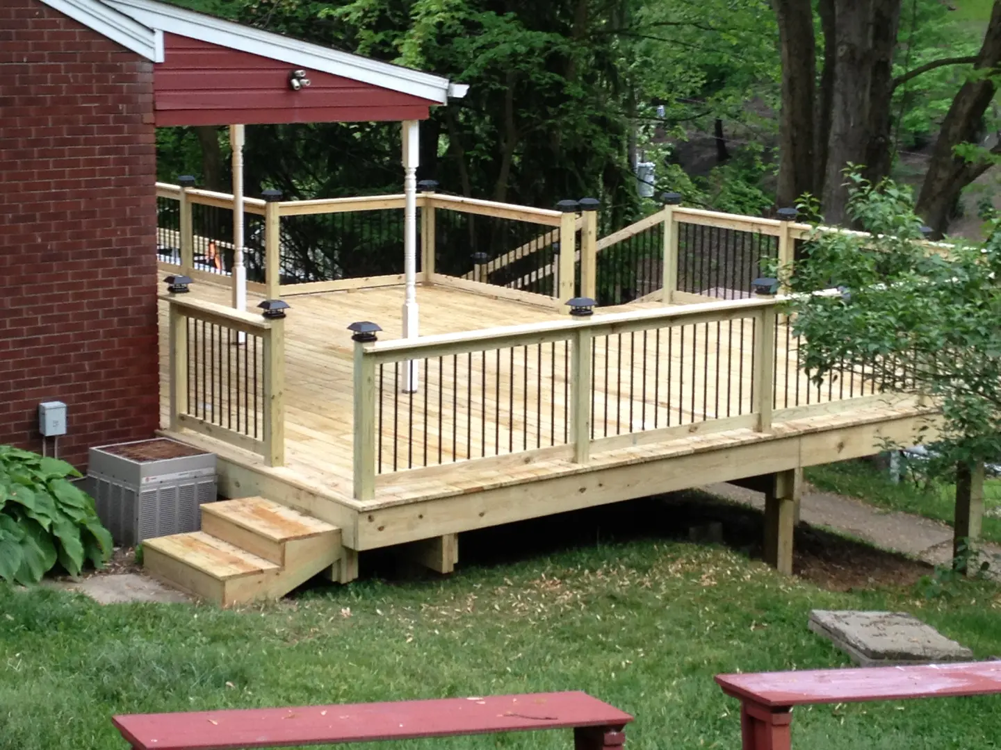 A wooden deck with railings and benches in the background.