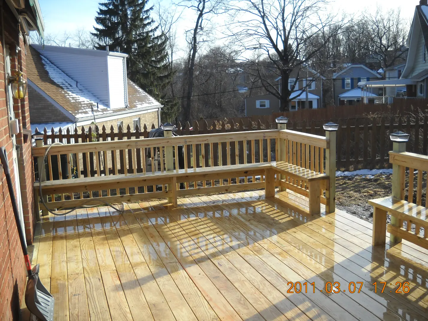 A wooden deck with benches and a bench over the top of it.