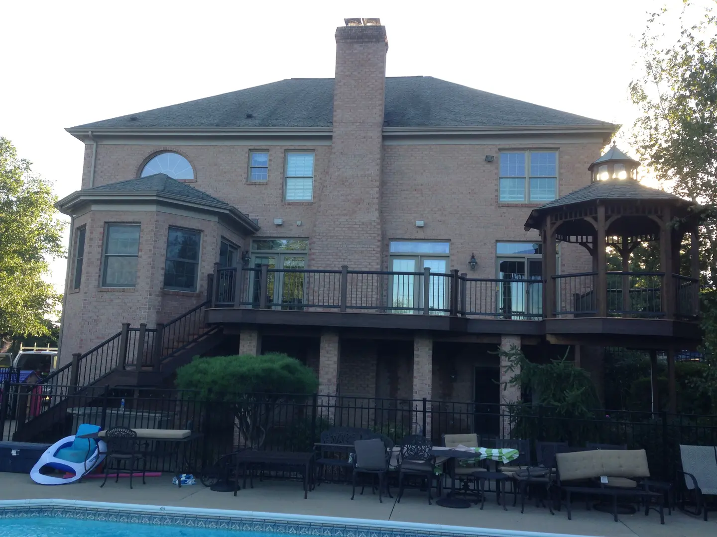 A large brick house with a pool in the back yard.