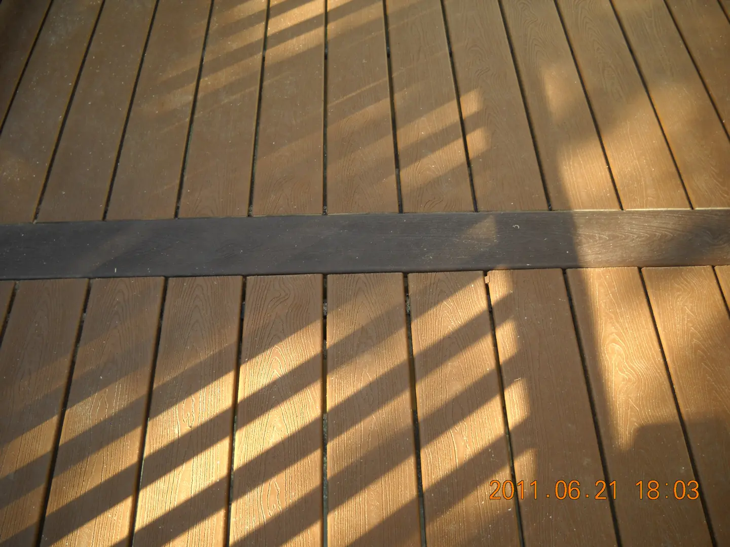 A wooden deck with some shadows on it