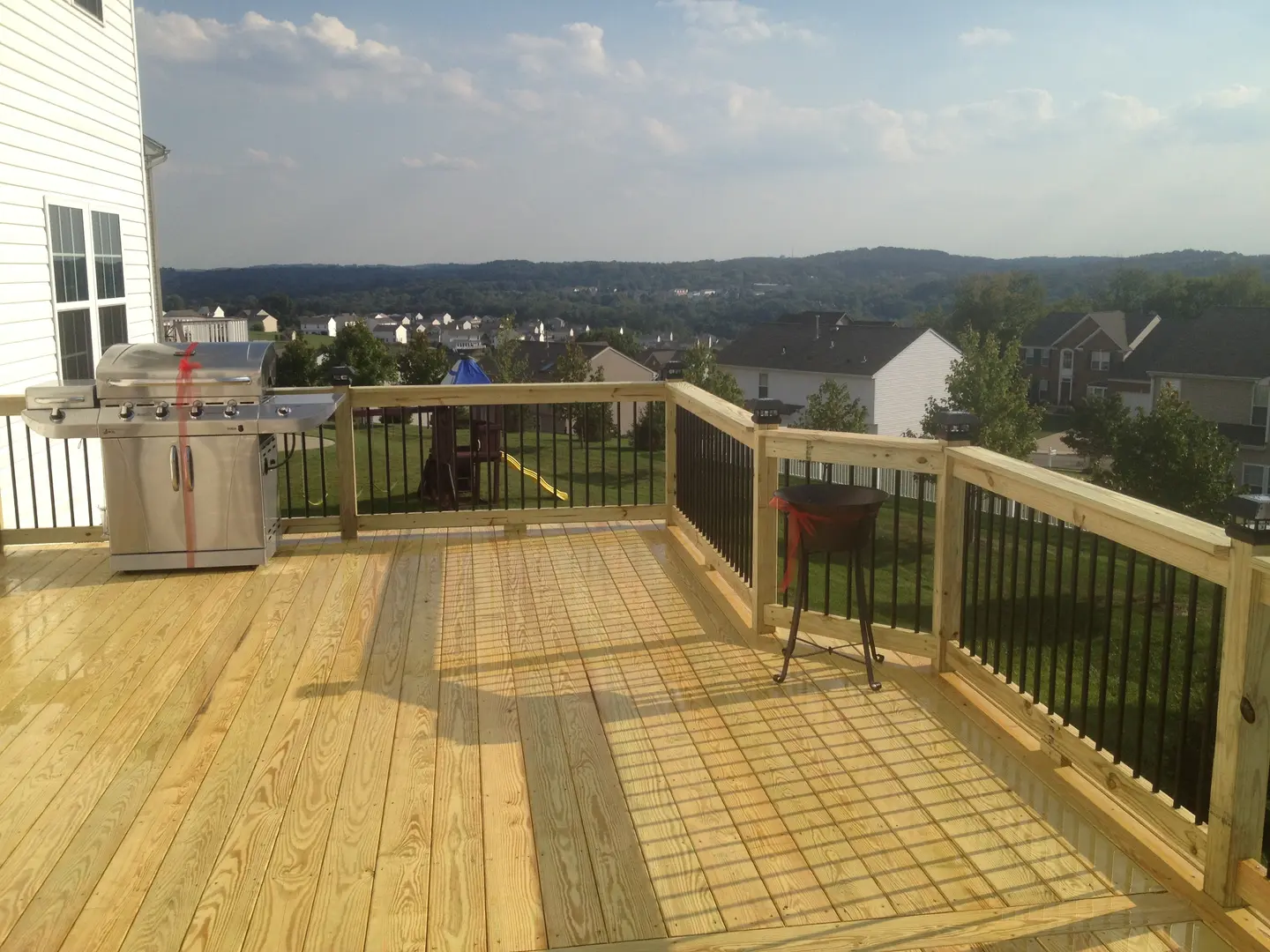 A deck with a view of the mountains and trees.