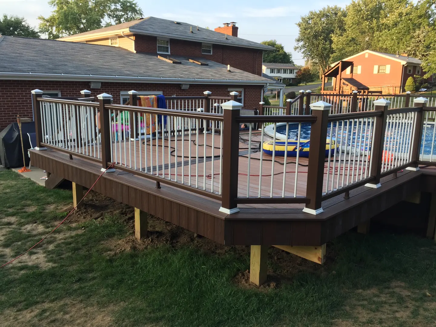 A deck with metal railing and posts in the grass.