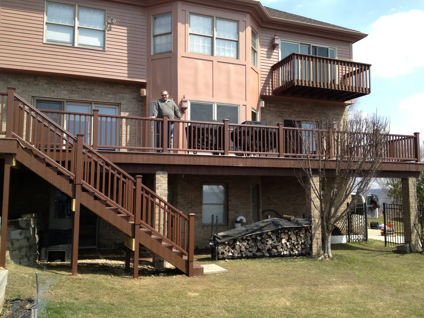 A man standing on the top of stairs in front of a house.