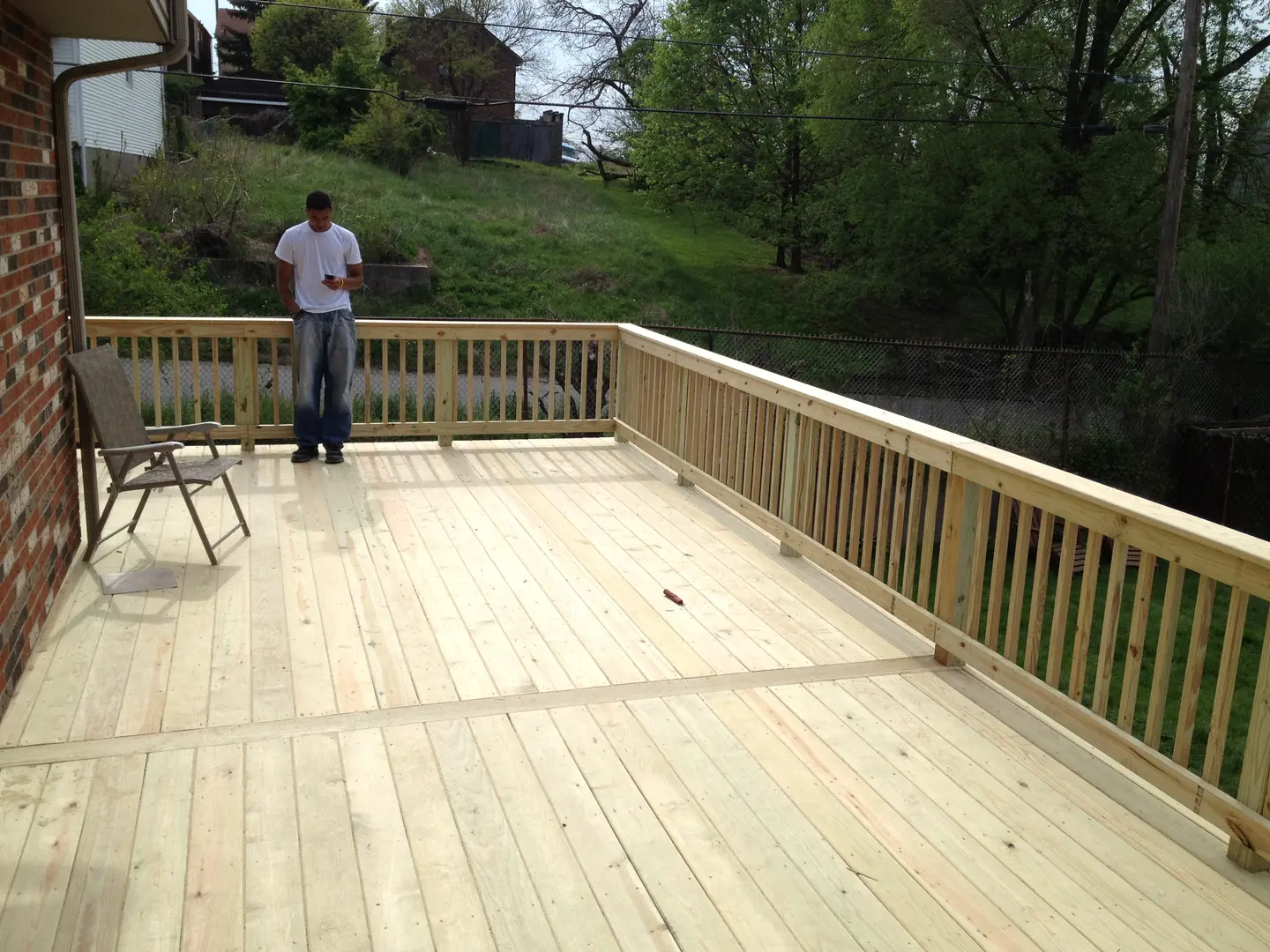 A man standing on top of a wooden deck.