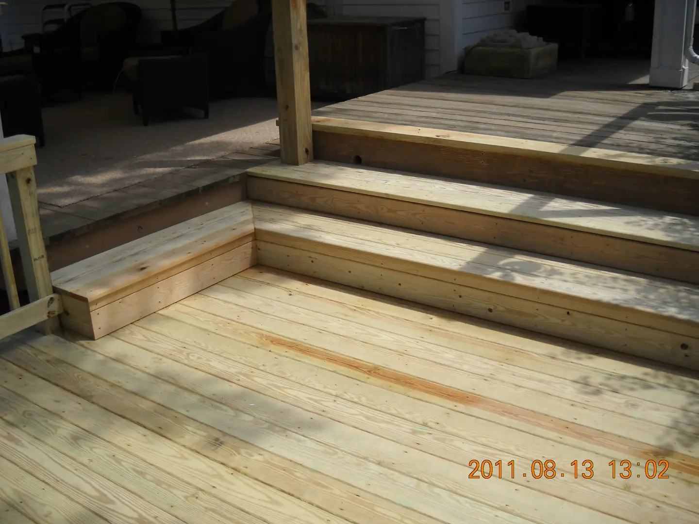 A wooden deck with steps and stairs in the middle.