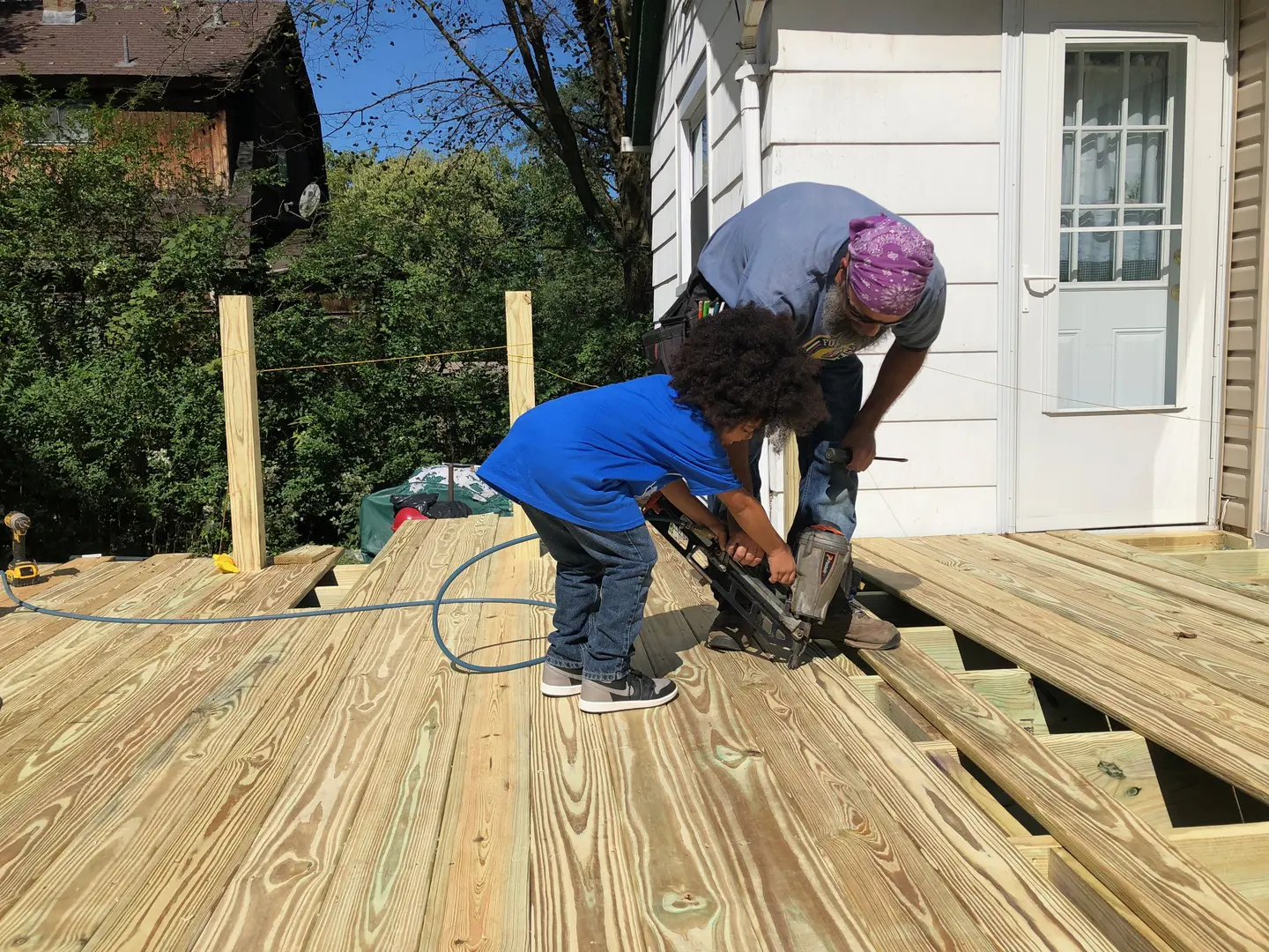 A man and child working on the deck of their home.